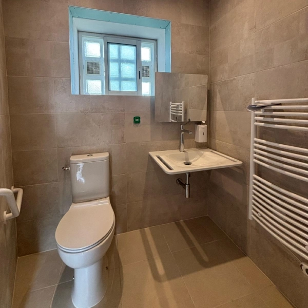 Photo de la partie lavabo, WC avec barre de maintien et sèche serviette